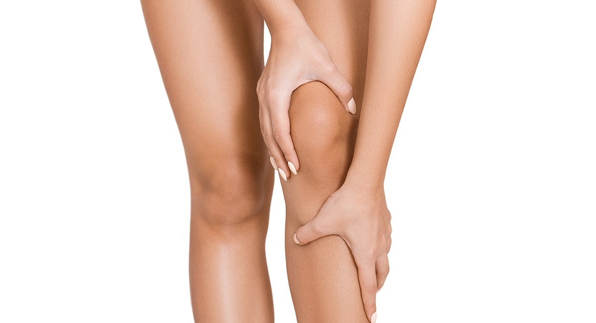 woman rubbing inflamed knee. cbd cream for pain. cbd salves for pain. best cbd cream for arthritis pain.
