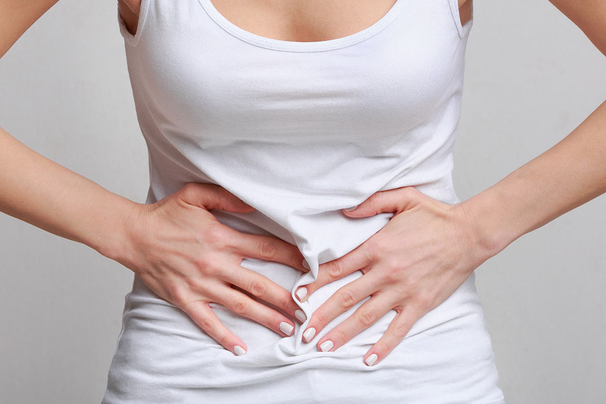 Woman with stomach ache. how to use cbd for cramps. cbd oil for heavy periods.