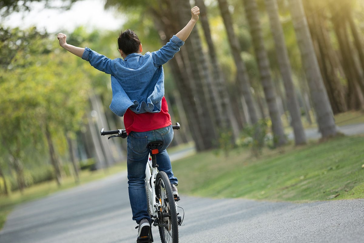 happy woman cycling in the forest. cbd concentration calculator.