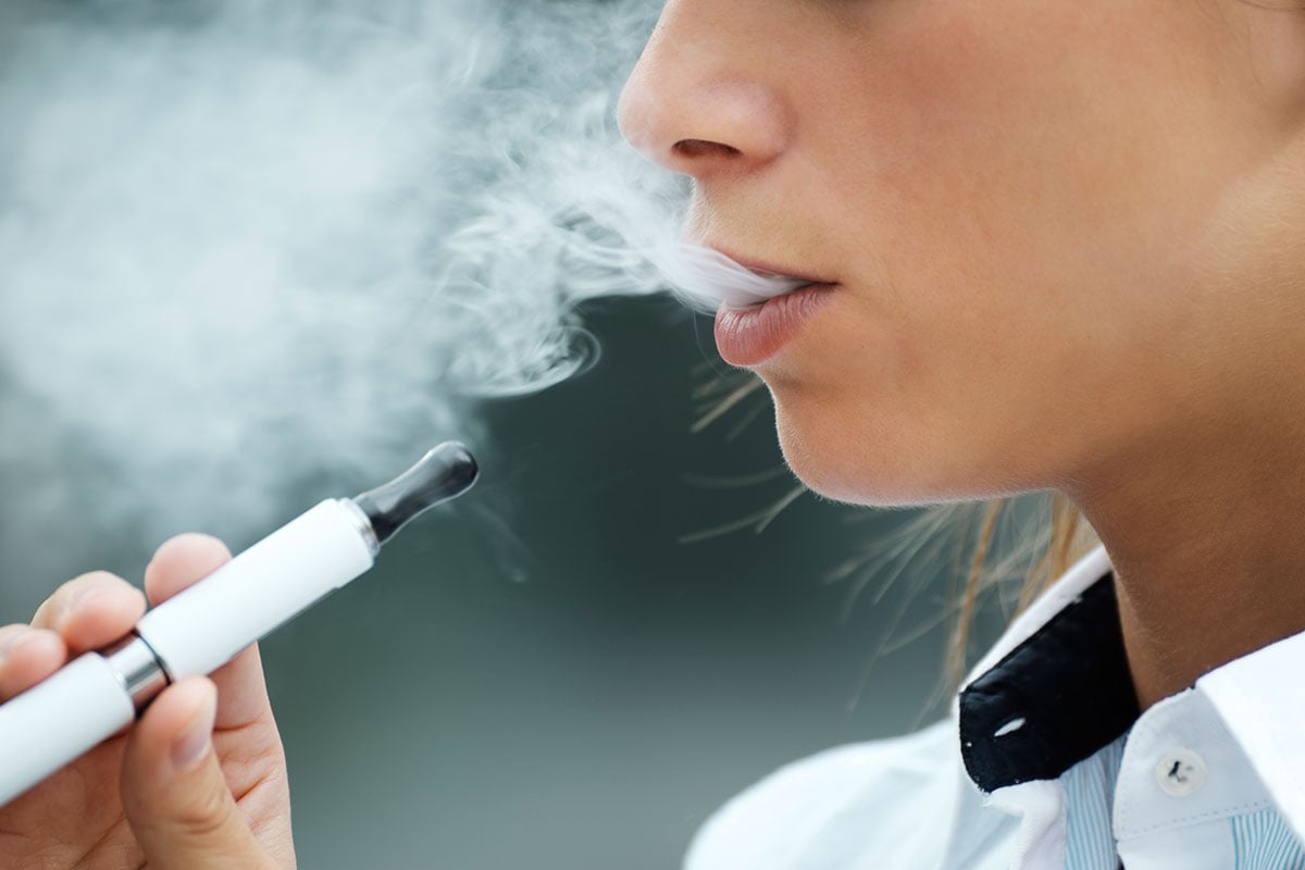 closeup of woman smoking electronic cigarette. buy cbd edibles online USA.